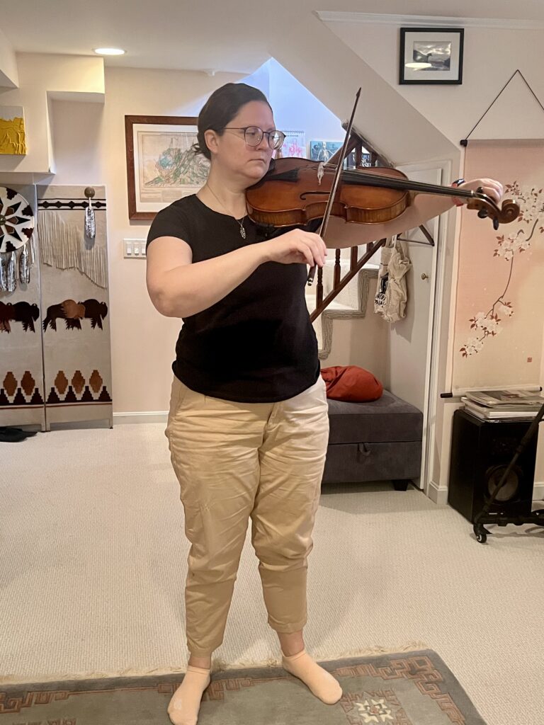 A violist preparing to play with centered posture during an Alexander Technique session with Tommy Thompson, embodying Use Is Self.