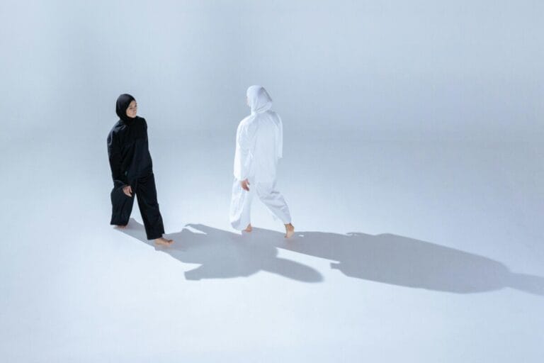 Two figures in black and white facing each other in motion, symbolizing internal conflict and the duality of movement identity in the Alexander Technique.