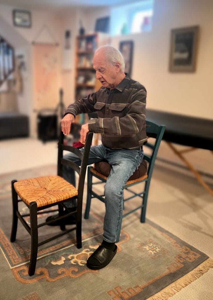 Tommy Thompson demonstrating “Hands on Back of Chair” during an Alexander Technique class, emphasizing the direction ‘Go to Your Back’ with trainees.
