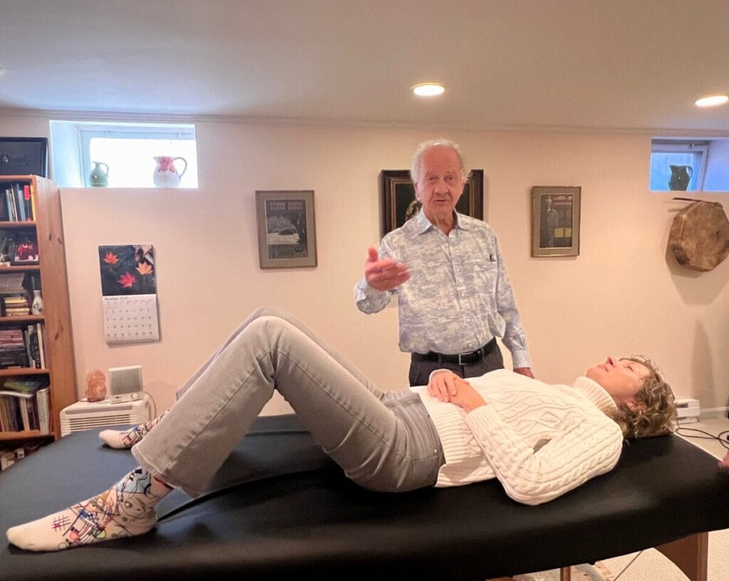 Tommy Thompson demonstrating Gravity Flow in an Alexander Technique class with a trainee in semi-supine position
