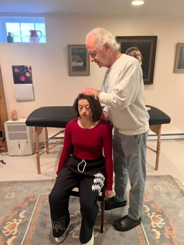 Tommy Thompson gently working with a trainee during an Alexander Technique class, demonstrating principles of how to use yourself through embodied awareness.