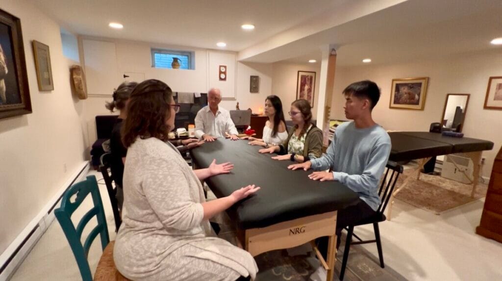 Trainees in an Alexander Technique class practice table work with Tommy Thompson,